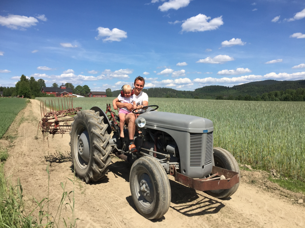 dad and girl drives old tractor